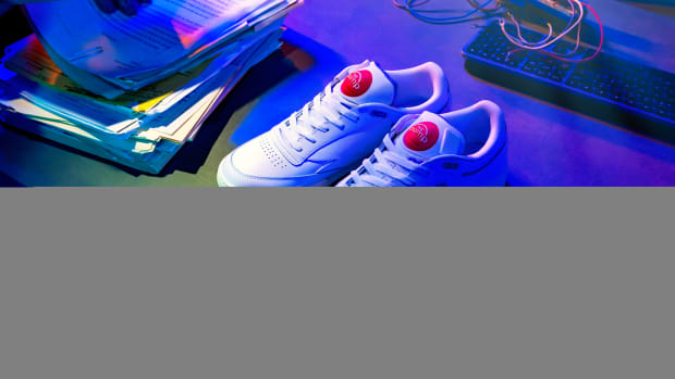 Overhead view of white and red Reebok shoes.